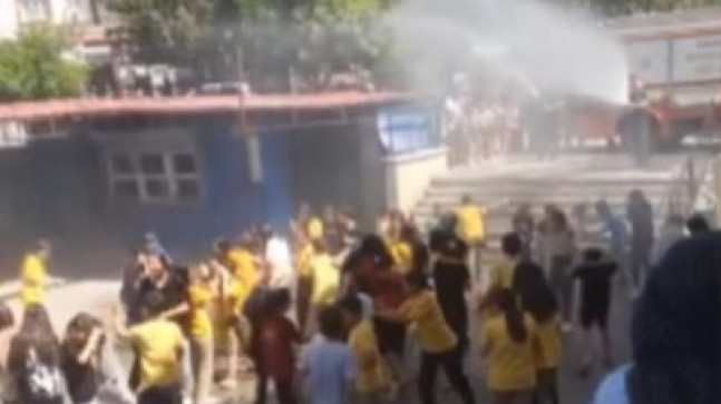 Adana’da  itfaiye ekipleri, sıcaktan bunalan ilkokul öğrencilerini su sıkarak serinletti