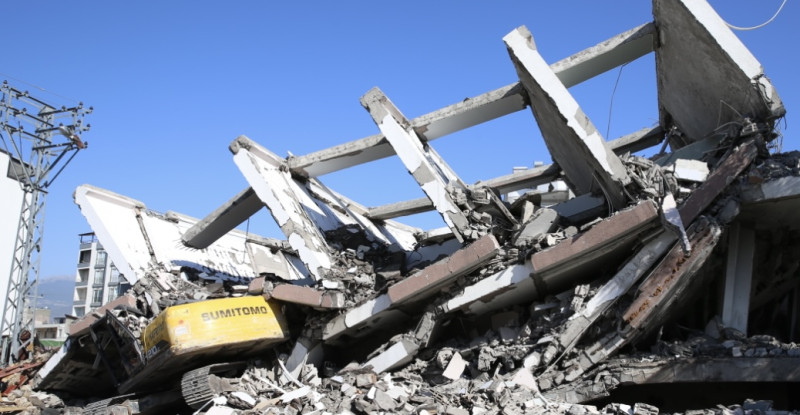 HATAY’DA AĞIR HASARLI BİNA YIKIM SIRASINDA İŞ MAKİNESİNİN ÜZERİNE ÇÖKTÜ! OPERATÖR YARALANDI…